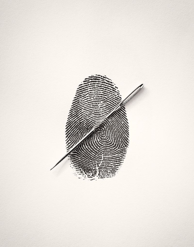 A sewing needle laid across a fingerprint